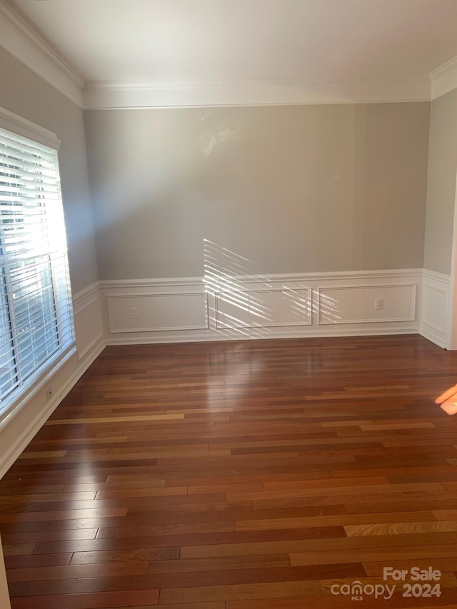 spare room featuring dark hardwood / wood-style floors and ornamental molding