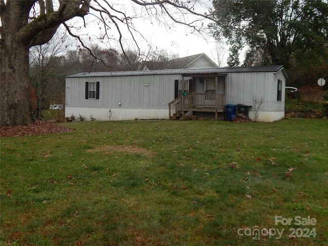 rear view of property with covered porch and a yard