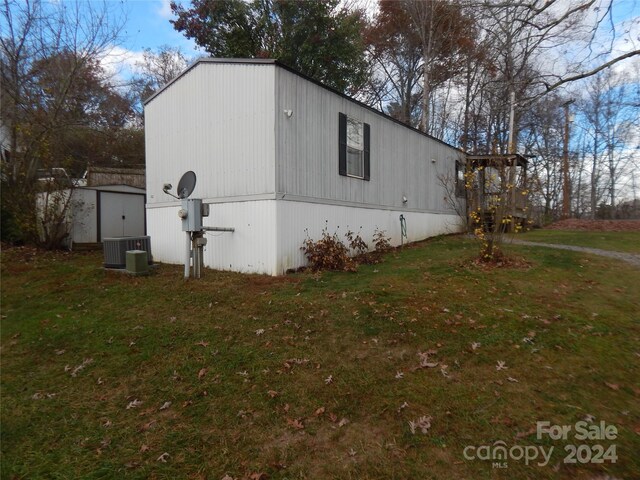 view of side of home featuring central air condition unit and a yard