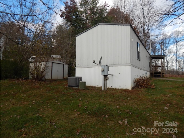 view of property exterior with a shed, a lawn, and central AC