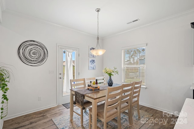 dining room with dark hardwood / wood-style floors and ornamental molding