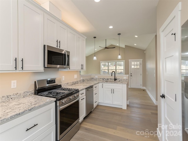 kitchen with stainless steel appliances, lofted ceiling, white cabinetry, light wood-type flooring, and decorative light fixtures