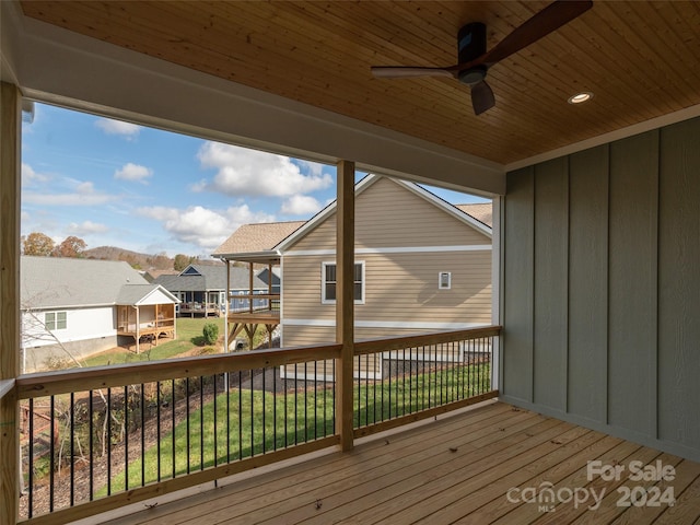 wooden deck featuring a lawn and ceiling fan