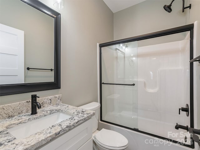 full bathroom with shower / bath combination with glass door, toilet, and vanity