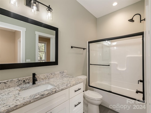 full bathroom with vanity, combined bath / shower with glass door, and toilet