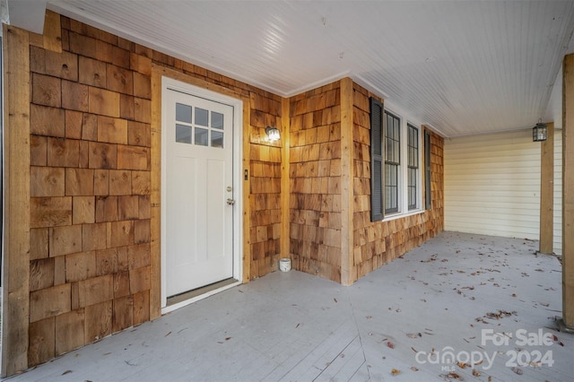 view of exterior entry featuring covered porch