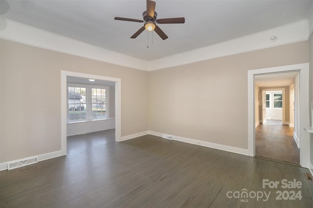 empty room featuring dark wood-type flooring and ceiling fan