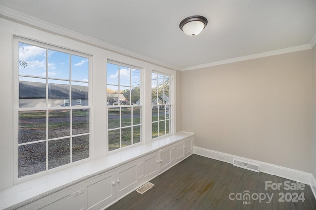 interior space with dark hardwood / wood-style flooring, ornamental molding, and plenty of natural light