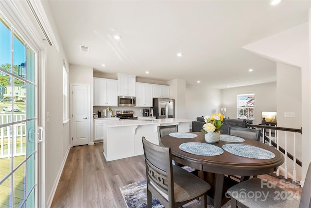 dining room with light hardwood / wood-style floors and sink