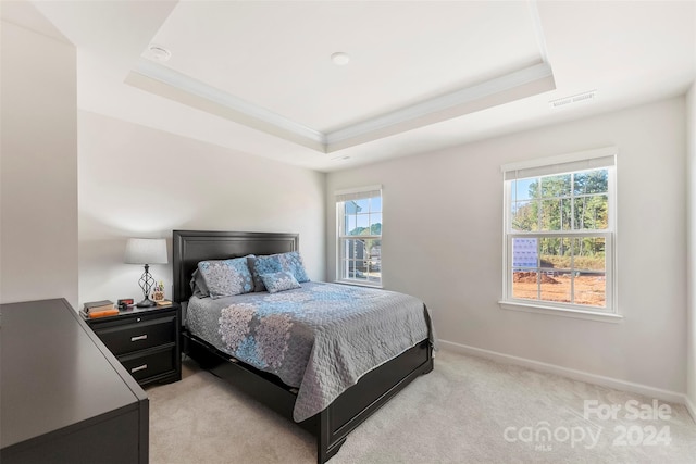 carpeted bedroom with ornamental molding, multiple windows, and a tray ceiling