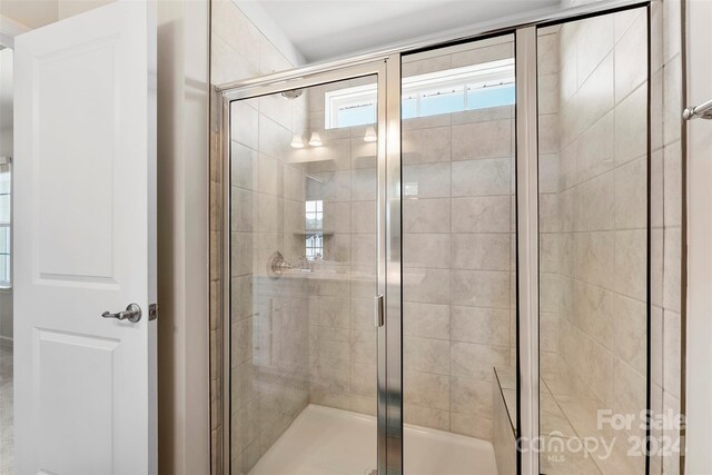 bathroom featuring a shower with shower door