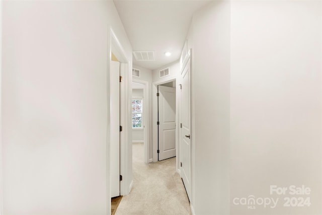 hallway featuring light colored carpet