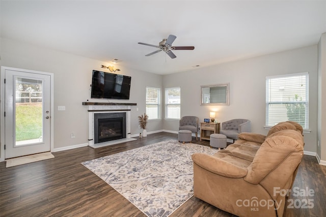 living room featuring dark hardwood / wood-style flooring, ceiling fan, and a wealth of natural light