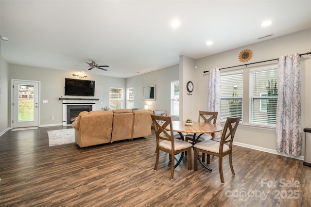 dining room featuring dark hardwood / wood-style flooring, ceiling fan, and a healthy amount of sunlight