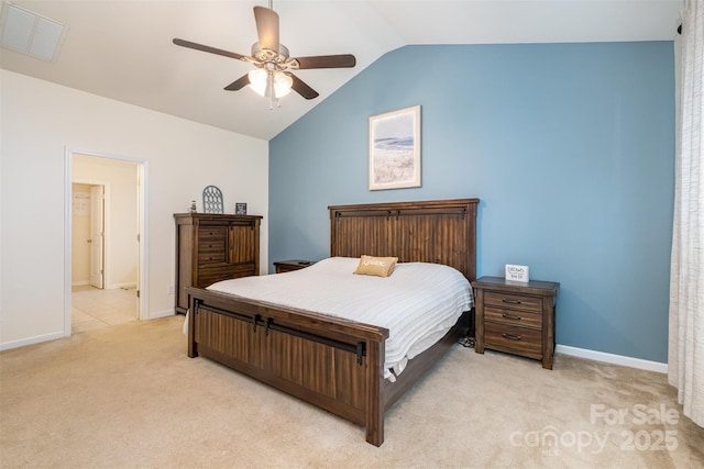 bedroom featuring ceiling fan, ensuite bathroom, vaulted ceiling, and light carpet