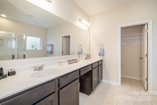 bathroom featuring vanity, tile patterned floors, and a shower with shower door