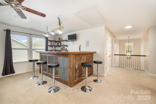 bar featuring ceiling fan, light carpet, and pendant lighting