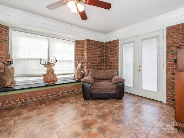 sitting room featuring a healthy amount of sunlight, brick wall, and french doors