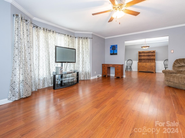 unfurnished living room featuring wood-type flooring, ceiling fan, and ornamental molding