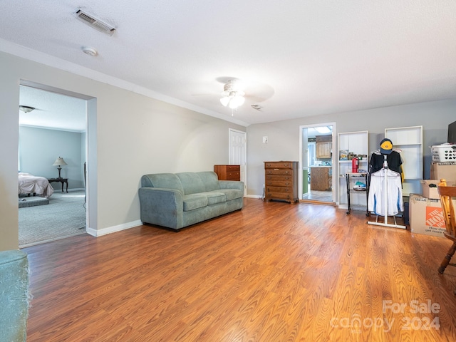 sitting room featuring wood-type flooring, a textured ceiling, and ceiling fan