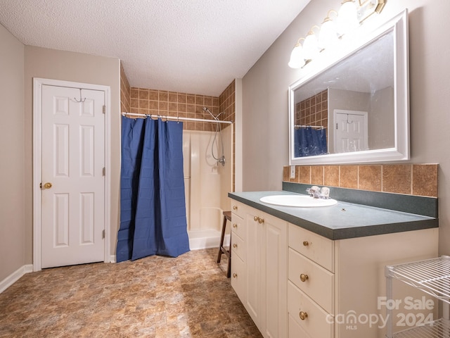 bathroom featuring vanity, a textured ceiling, and walk in shower