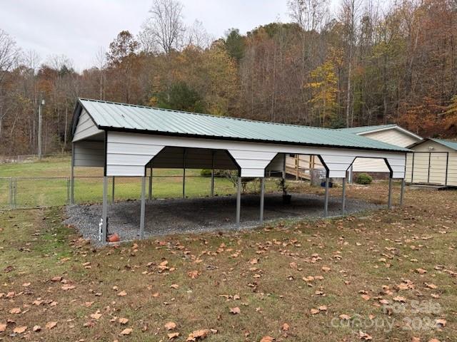 view of vehicle parking featuring a lawn and a carport