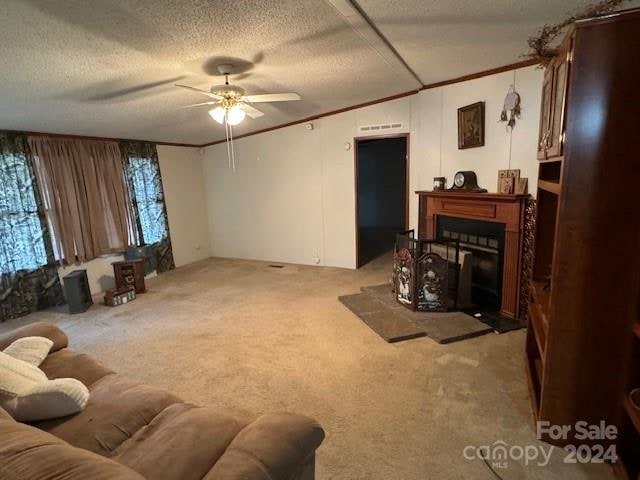 living room featuring ornamental molding, a textured ceiling, light colored carpet, and ceiling fan