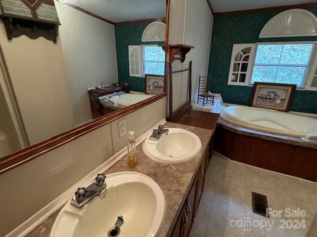 bathroom with ornamental molding, plenty of natural light, vanity, and a bath