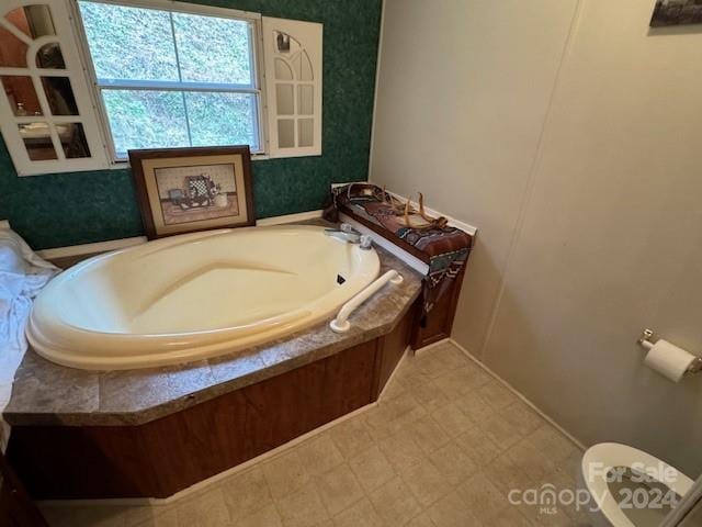 bathroom with a washtub and toilet