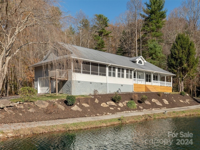 view of front of property with a sunroom and a water view