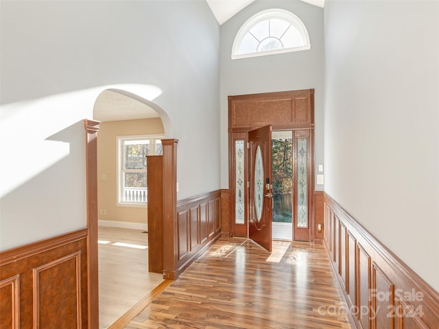 entrance foyer featuring high vaulted ceiling and wood-type flooring