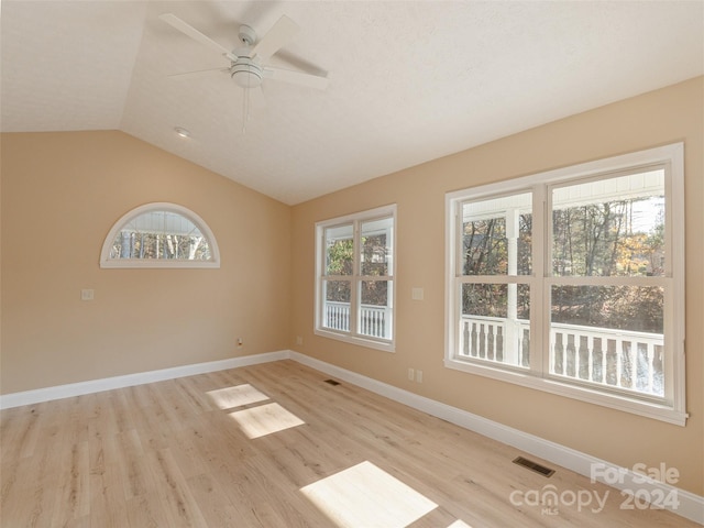 spare room featuring ceiling fan, light hardwood / wood-style flooring, and lofted ceiling