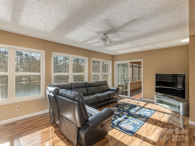 living room with a textured ceiling and light hardwood / wood-style floors