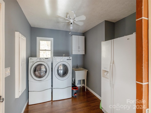 clothes washing area featuring a textured ceiling, dark hardwood / wood-style flooring, cabinets, washing machine and clothes dryer, and ceiling fan