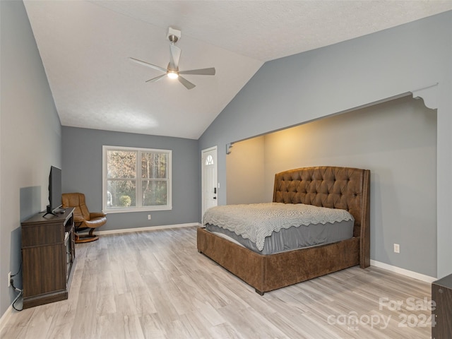 bedroom featuring light hardwood / wood-style floors, ceiling fan, a textured ceiling, and vaulted ceiling