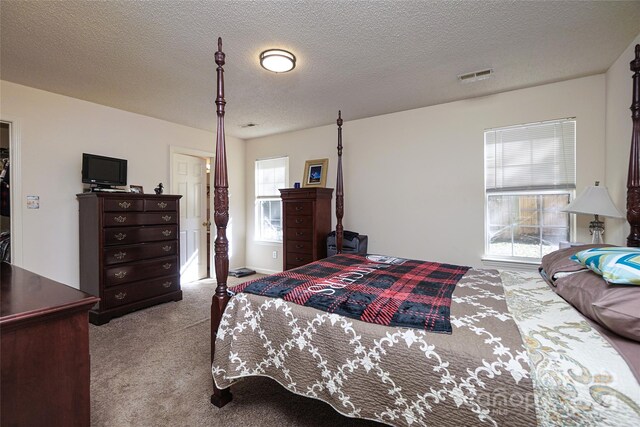 bedroom with light carpet and a textured ceiling