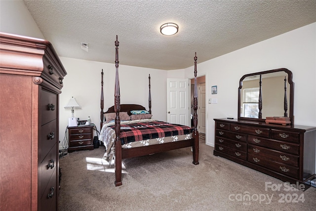 bedroom featuring a textured ceiling and carpet flooring