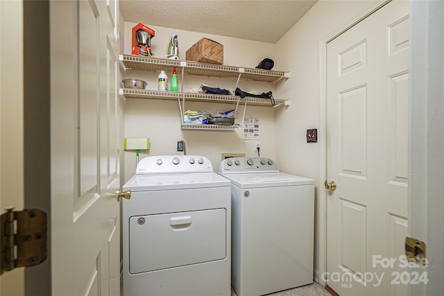 laundry room featuring separate washer and dryer and a textured ceiling