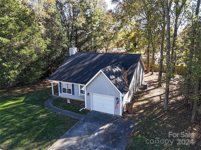 view of front of home with cooling unit, a front lawn, and a garage