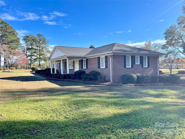 5486 Kershaw Camden Hwy, Heath Springs, SC 29058 - view of front of house featuring covered porch, a front lawn, a chimney, and brick siding