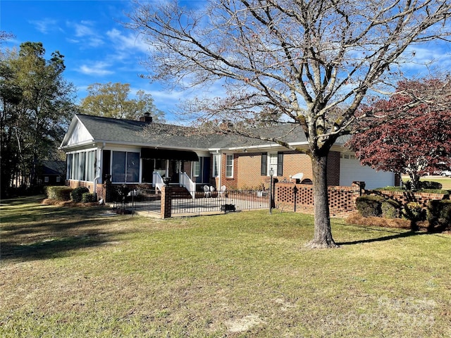 back of property featuring a sunroom, a garage, and a yard