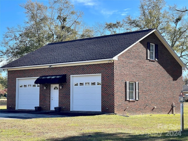 view of side of home with a yard and a garage