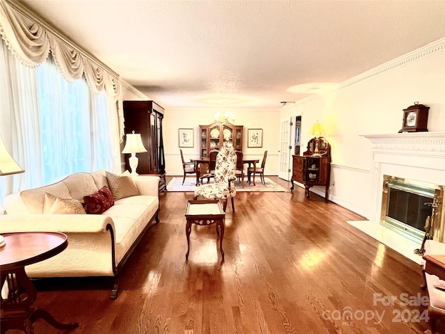 living room featuring wood-type flooring, a textured ceiling, an inviting chandelier, and crown molding