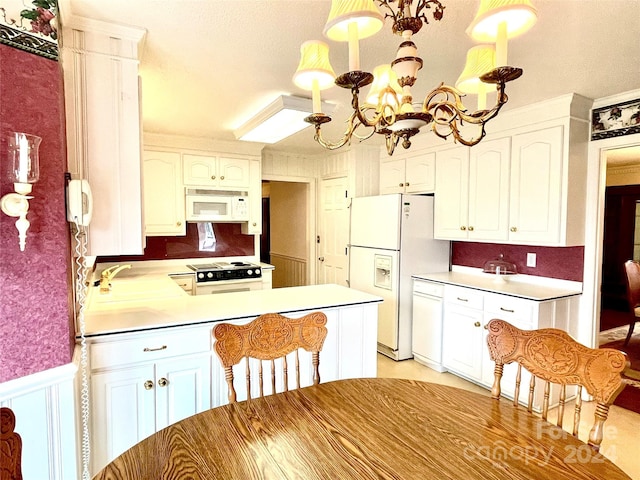 kitchen with white cabinets, white appliances, and hanging light fixtures