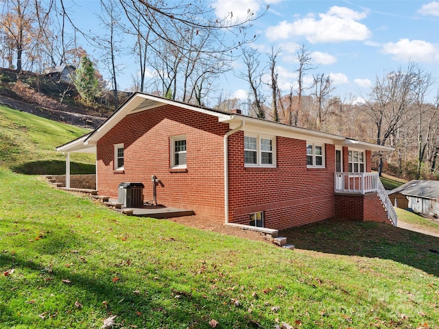 view of side of home featuring central AC unit and a lawn