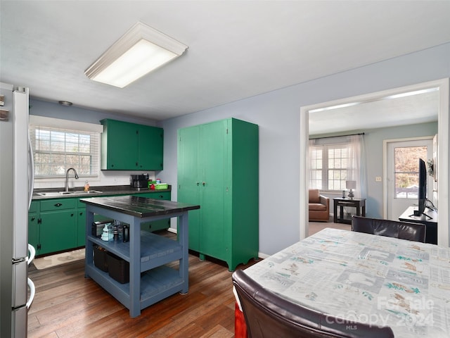 kitchen featuring dark wood-type flooring, a wealth of natural light, sink, and white fridge