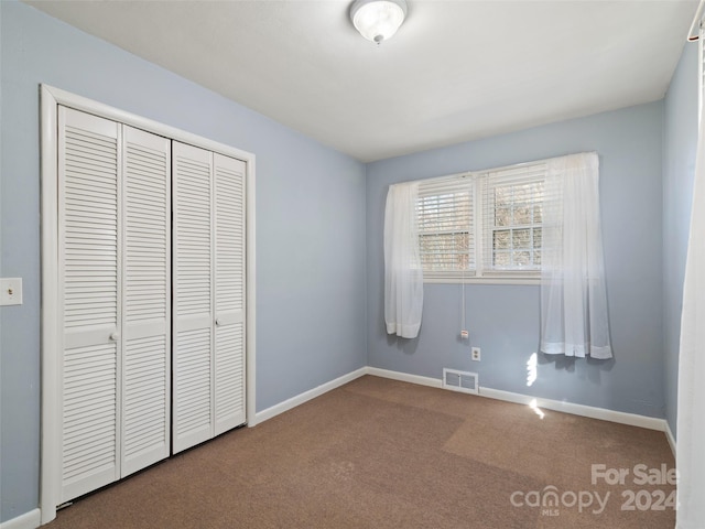 unfurnished bedroom featuring a closet and carpet floors