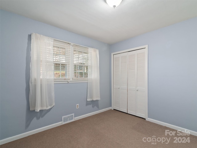 unfurnished bedroom with a closet and carpet floors