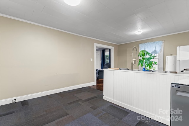 kitchen with dark carpet, ornamental molding, and white refrigerator