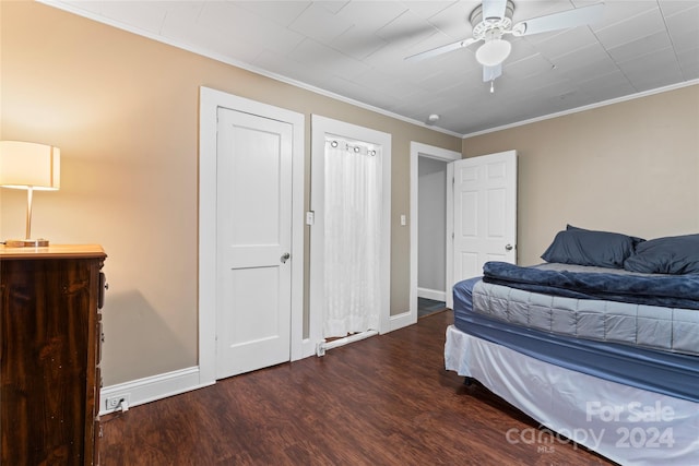 bedroom with dark hardwood / wood-style flooring, ceiling fan, and ornamental molding